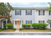 Charming townhome with light blue siding, black shutters, tidy landscaping, and a peach-colored front door at 153 Heritage Cir # K3, Mount Pleasant, SC 29464
