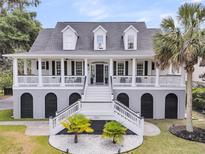 Stunning two-story home featuring a grand entrance, double staircases, and a charming front porch at 1711 Indigo Island Dr, Hanahan, SC 29410