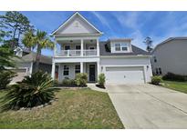 Charming two-story home with a front balcony, attached garage, and manicured landscaping enhancing its curb appeal at 203 Yeamans Way, Summerville, SC 29483