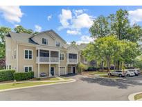 Inviting two-story townhomes with covered porches and attached garages on a sunny day at 2121 Egret Crest Ln, Charleston, SC 29414