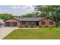 Charming brick home featuring a two-car garage and a beautifully landscaped front yard at 2864 Wofford Rd, Charleston, SC 29414