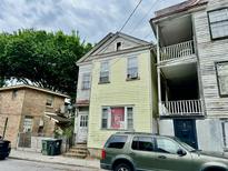 Two-story home featuring light yellow siding and traditional architectural details at 3 Hanover St, Charleston, SC 29403