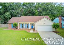Charming one-story home with a manicured lawn, bright blue accents, and inviting front porch seating at 300 Hamlet Rd, Summerville, SC 29485