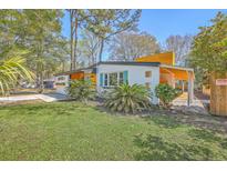 Charming single-story home with a well-manicured lawn, palm trees, and a unique architectural design at 32 Briarcliff Dr, Charleston, SC 29407