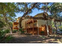 Multi-level condo with wooden balconies, set amongst lush trees, offering serene outdoor living at 339 Sea Cloud Cir, Edisto Island, SC 29438
