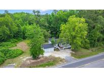 Aerial view of home with two-car garage surrounded by mature trees and lush greenery at 358 Highway 78, Ridgeville, SC 29472
