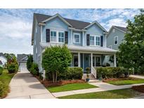 Charming light blue two-story home with a covered porch and well-manicured landscaping at 3656 Spindrift Dr, Mount Pleasant, SC 29466