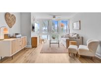 Bright living room features light hardwood floors and plush seating near large windows offering beautiful waterfront views at 5 Mariners Cay Dr, Folly Beach, SC 29439