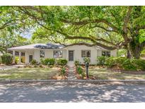 Charming single-story home featuring a manicured lawn, lush greenery, and mature shade tree at 5155 Monterey St, North Charleston, SC 29405
