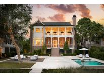 Stunning two-story brick home featuring a covered porch, pool, and lush landscaping at 80 On The Harbor Dr, Mount Pleasant, SC 29464
