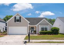 Charming single-story home with well-maintained lawn and attached two car garage at 1315 Palm Cove Dr, Charleston, SC 29492