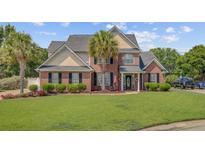 Beautiful two-story brick home with manicured lawn, mature landscaping, and a welcoming front entrance at 1503 Pondside Ct, Summerville, SC 29485