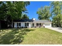 Charming single-story home with a well-manicured lawn, mature trees, and a welcoming front porch at 1534 Kentwood Cir, Charleston, SC 29412