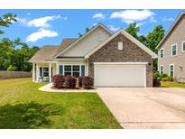 Charming single-Gathering home featuring a two-car garage, well-manicured lawn, and inviting curb appeal at 1610 Fishbone Dr, Johns Island, SC 29455