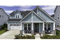 Charming two-story home featuring a covered front porch, a well-maintained lawn, and an attached two-car garage at 172 Helena Park Dr, Summerville, SC 29486