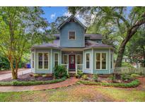 Charming two-story home with light blue siding, bay windows, brick walkway, and mature landscaping at 1830 Kempton Ave, James Island, SC 29412