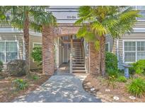 Welcoming walkway leads to the building entrance, framed by lush landscaping and mature palm trees at 188 Midland Pkwy # 516, Summerville, SC 29485
