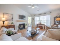 Bright living room with white furniture, fireplace, mounted tv, and lots of natural light at 2011 N Highway 17 # 2300F, Mount Pleasant, SC 29466