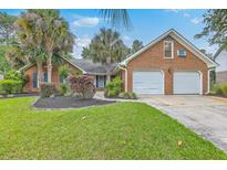 Charming brick home featuring a two-car garage, mature palm trees, and neatly manicured landscaping at 2120 Fife Ln, Charleston, SC 29414
