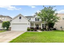 Charming two-story home featuring a two-car garage, well-manicured lawn, and welcoming front porch at 218 Austin Creek Ct, Summerville, SC 29483