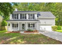 Charming two-story home featuring a welcoming front porch, well-maintained lawn, and attached garage at 240 Eagle Ridge Rd, Summerville, SC 29485
