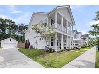 Charming two-story home with white siding, a covered front porch, and a detached garage at 2844 Pinelog Ln, Johns Island, SC 29455