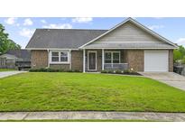 Charming single-story brick home with a well-maintained lawn and attached garage at 313 Janice St, Goose Creek, SC 29445