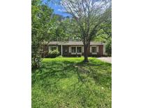 Charming single-story brick home featuring lush lawn and mature trees in a tranquil setting at 33 Roselle Ave, Goose Creek, SC 29445