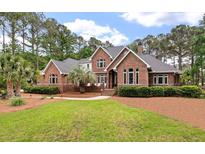 Stunning brick home with mature landscaping, lush lawn, and inviting walkway at 3601 Colonel Vanderhorst Cir, Mount Pleasant, SC 29466