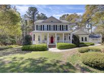 Inviting two-story home with a charming front porch and a bright red front door at 4233 Lady Banks Ln, Ravenel, SC 29470