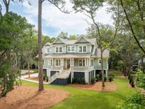 Charming two-story home with a welcoming front porch, lush landscaping, and beautiful architectural details at 4291 Turtle Landing Ct, Johns Island, SC 29455
