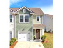 Charming two-story home with a one-car garage and a welcoming front porch with a decorative wreath at 4966 Hay Bale Ct, Summerville, SC 29485