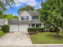 Charming two-story home featuring blue shutters, a well-maintained lawn, and an attached two-car garage at 5406 Woodbreeze Dr, North Charleston, SC 29420
