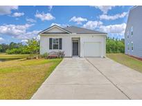 Charming single-story home with well-manicured lawn, pond view, and attached garage at 1011 Peridote Way, Ladson, SC 29456