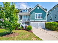 Charming two-story home featuring a porch, well-manicured lawn, and two-car garage at 104 Antilles Cir, Charleston, SC 29492