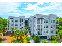 Stunning aerial view of a luxury condo building with beautiful landscaping and modern architecture at 108 Fairbanks Oak Aly # 401, Charleston, SC 29492