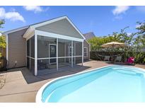 Beautiful backyard featuring an in-ground pool and screened-in porch with outdoor furniture and patio for entertaining at 1110 Flyway Rd, Summerville, SC 29483
