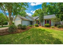 Charming single-story home with light blue siding, lush green lawn and tasteful landscaping at 115 Sully St, Goose Creek, SC 29445