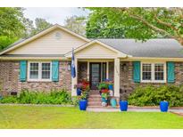 Charming brick home featuring teal shutters, a well manicured front yard and delightful curb appeal at 1158 Shoreside Way, Mount Pleasant, SC 29464