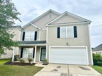 Charming two-story home with black shutters, a two-car garage, and a well-manicured lawn in a suburban neighborhood at 1401 Dabbling Duck Dr, Summerville, SC 29483