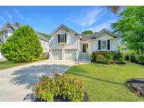 Charming two-story home with attached two-car garage, manicured lawn, and blooming flower beds at 1582 Ocean Neighbors Blvd, Charleston, SC 29412