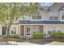 Inviting townhome with brick accents, manicured landscaping, and a covered entryway at 302 Elm Hall Cir, Summerville, SC 29483