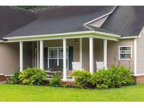 Inviting covered porch with rocking chairs and lush landscaping offers a relaxing outdoor space at 3113 Edenvale Rd, Johns Island, SC 29455