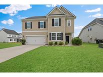 Charming two-story home with a well-manicured lawn and attached two-car garage at 320 Blue Shadows Ct, Summerville, SC 29486