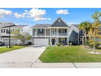 Charming two-story home with a well-manicured lawn and inviting front porch at 342 Saxony Loop, Summerville, SC 29486