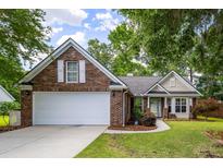 Brick home with a two-car garage, white shutters, and manicured landscaping at 420 Manorwood Ln, Charleston, SC 29414
