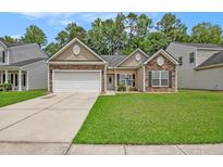 Charming single-story home features a two-car garage and well-manicured lawn in a suburban neighborhood at 541 Brick Barn Ln, Goose Creek, SC 29445