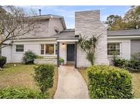 Charming home featuring a textured chimney, well-maintained landscaping, and a welcoming entrance at 718 Parish Rd, Charleston, SC 29407