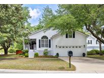 Charming white two-story home with an attached two-car garage and a well-manicured front lawn at 638 Stono Edge Dr, Charleston, SC 29412
