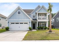 Charming two-story home with blue siding, a front porch balcony, and a well-maintained front yard at 8402 Loggers Run, North Charleston, SC 29420